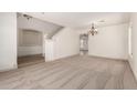 Bright, open-concept living room with neutral carpet and elegant chandelier at 82 N 221St Ave, Buckeye, AZ 85326