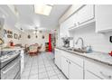 Well-lit kitchen showcasing white cabinetry and an open layout to the dining space at 13428 N Hawthorn Dr, Sun City, AZ 85351