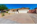 Charming single-story home with desert landscaping, a stone facade, and a two-car garage at 1611 W Palomino Dr, Chandler, AZ 85224