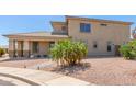 Tan stucco two-story home with desert landscaping and small palm tree at 16217 N 154Th Dr, Surprise, AZ 85374