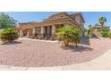 Two-story home with tan stucco, covered parking, desert landscaping, and tile roof at 16217 N 154Th Dr, Surprise, AZ 85374
