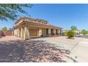 Two-story home with tan stucco, covered parking, desert landscaping, and tile roof at 16217 N 154Th Dr, Surprise, AZ 85374