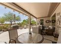 Covered outdoor patio featuring comfortable seating, a dining area, and serene desert views at 17359 W Calistoga Dr, Surprise, AZ 85387