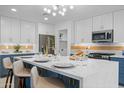 Modern kitchen featuring a large island, white cabinets, stainless steel appliances, and stylish light fixture at 1818 W Highland Ave, Phoenix, AZ 85015