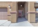 Inviting front door and arched entryway, framed by decorative pillars and outdoor lighting at 1923 N Cocoa Ct, Casa Grande, AZ 85122