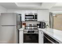 Close up of a modern kitchen with stainless appliances, white cabinets, and marble countertops at 2021 E Osborn Rd # 9, Phoenix, AZ 85016