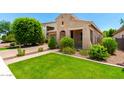 Charming single-story home featuring lush landscaping and a brick-paved driveway at 20563 W Edgemont Ave, Buckeye, AZ 85396