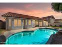 Relaxing backyard showcasing a pool and the home's exterior under a colorful evening sky at 3220 W Frankfurt Dr, Chandler, AZ 85226