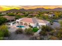 Breathtaking aerial view of a luxury home showcasing a private pool, mountain views, and desert landscaping at sunset at 3946 N Pinnacle Hills Cir, Mesa, AZ 85207