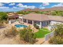 A captivating backyard with a sparkling pool, built-in grill, lounge chairs, and lush desert landscaping at 3946 N Pinnacle Hills Cir, Mesa, AZ 85207
