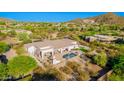 Aerial view of a home featuring a pool, spa, and desert landscaping, set against a backdrop of mountain views at 3946 N Pinnacle Hills Cir, Mesa, AZ 85207