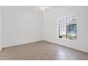 Bright room showcasing a large window, neutral walls, and ceramic tile flooring at 3977 E Cat Balue Dr, Phoenix, AZ 85050