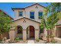 Charming two-story home with a red door, desert landscaping and an arched front entryway at 5812 W Illini St, Phoenix, AZ 85043