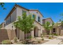 Charming two-story home with a red door, desert landscaping and an arched front entryway at 5812 W Illini St, Phoenix, AZ 85043