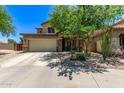 Inviting front exterior featuring a two-car garage, desert landscaping, and a covered porch area at 7031 W Lone Tree Trl, Peoria, AZ 85383