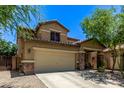 View of home with a two-car garage, desert landscaping, and covered porch area, situated with trees in the front yard at 7031 W Lone Tree Trl, Peoria, AZ 85383