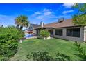 Expansive backyard featuring a well-maintained lawn, large pool, and mature shade trees at 7526 W Cheryl Dr, Peoria, AZ 85345