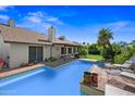 Backyard pool with tiled trim, lounge chairs, verdant grass and mature landscaping at 7526 W Cheryl Dr, Peoria, AZ 85345