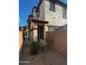 Townhouse exterior featuring stucco, an arched entry, and a privacy wall at 876 S Colonial Dr, Gilbert, AZ 85296