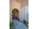 Inviting front porch with arched entry, colorful potted plants, and a red bench at 10655 N 9Th St # 112, Phoenix, AZ 85020