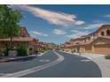 Scenic community street view displaying beautiful townhomes with desert landscaping under a bright sky at 10655 N 9Th St # 112, Phoenix, AZ 85020