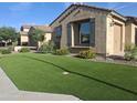 Landscaped front yard featuring lush green turf, flowering bushes and a cozy, inviting facade at 10773 W Prickly Pear Trl, Peoria, AZ 85383