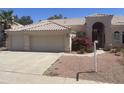 Attractive home with a three-car garage, a tile roof, and a desert landscape with colorful flowers at 11109 W Amelia Ave, Avondale, AZ 85392