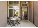 Cozy front porch area with a small table and chairs, creating a welcoming entry to the home at 15020 N 54Th Pl, Scottsdale, AZ 85254