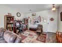 Comfortable office space with a desk, bookshelves, and a cozy chair next to a bright window at 17766 W Caribbean Ln, Surprise, AZ 85388