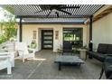 Inviting outdoor patio featuring stylish seating, a sleek pergola, and a modern front door at 1861 W Navarro Ave, Mesa, AZ 85202