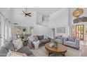 Bright living room with high ceilings, wood floors, neutral furniture and a staircase in the background at 1991 W Bartlett Ct, Chandler, AZ 85248