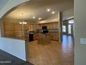 Well-lit kitchen featuring tile floors, a central island, and abundant wood cabinetry at 2092 E Smoke Tree Rd, Gilbert, AZ 85296