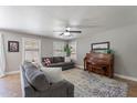 Comfortable living room featuring a ceiling fan, couch, piano, and large windows at 3047 S Mandy St, Mesa, AZ 85212