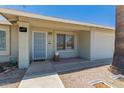 Charming house exterior showcasing a secure entry, gravel landscaping, and a well-lit porch at 3447 E Dolphin Ave, Mesa, AZ 85204