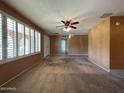 Spacious living room featuring neutral carpet, multiple windows, and a ceiling fan at 3740 E Mercer Ln, Phoenix, AZ 85028