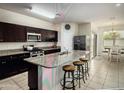 This spacious kitchen features granite countertops, a center island, stainless steel appliances, and sleek dark cabinetry at 4061 N 308Th Ln, Buckeye, AZ 85396