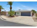 Well-maintained home with a two-car garage, desert landscape, and a palm tree at 4347 E Catalina Cir, Mesa, AZ 85206