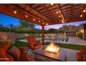 Relaxing outdoor seating area with a fire pit overlooking the pool and lush landscaping at 4518 E Solano Dr, Phoenix, AZ 85018