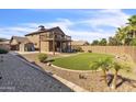Home backyard with a small deck, artificial grass, and desert landscaping at 4547 E Buist Ave, Phoenix, AZ 85044