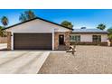 Inviting single-story home with a two-car garage, desert landscaping, and a cozy front porch at 527 N Criss St, Chandler, AZ 85226