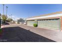 Exterior of the property with detached garages, tidy landscaping, and a well-paved driveway at 7111 N 63Rd Dr, Glendale, AZ 85301