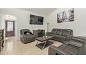 A cozy living room with modern leather seating, a fireplace, and tiled flooring at 7111 N 63Rd Dr, Glendale, AZ 85301