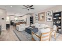 Open-concept living room with white sofas, dark blue ottoman, rug, and a combined kitchen area in background at 820 N 8Th Ave # 14, Phoenix, AZ 85007