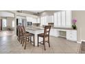 Bright kitchen featuring white cabinets, stainless steel appliances, a center island with seating, and tile flooring at 925 W San Marcos Dr, Chandler, AZ 85225