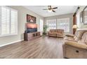 Comfortable living room with wood floors, a ceiling fan, plantation shutters, and a cozy seating area at 925 W San Marcos Dr, Chandler, AZ 85225