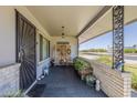 Inviting covered front porch with seating, decorative screens, and attractive tile flooring at 11135 W Cameo Dr, Sun City, AZ 85351