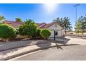 Inviting single-story home with a red tile roof, lush greenery, and a convenient two-car garage at 1201 E Campbell Ave, Gilbert, AZ 85234