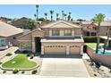 Charming two-story home featuring a three-car garage, desert landscaping, and mature palm trees at 15229 S 18Th Dr, Phoenix, AZ 85045