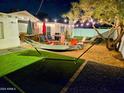 Inviting backyard retreat featuring a hammock, string lights, and comfortable seating around a modern fire pit at 1801 N 87Th Pl, Scottsdale, AZ 85257