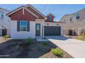 Charming single-Gathering home featuring a two-car garage, contrasting trim, and low maintenance desert landscaping at 18047 W Long Lake Rd, Goodyear, AZ 85338